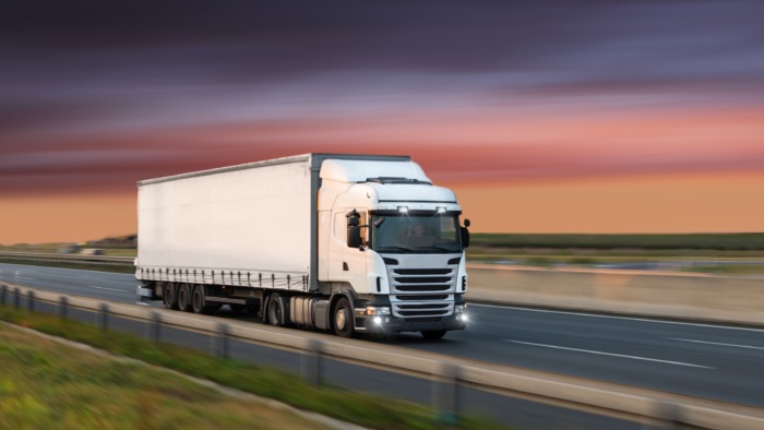 truck driving on road at sunset